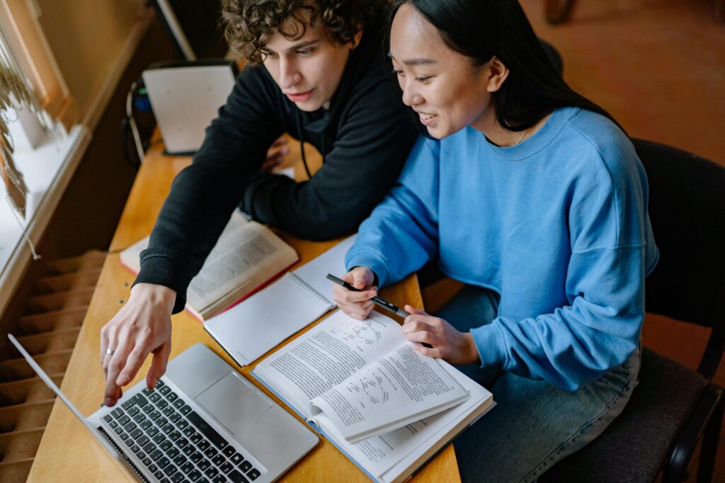 Pessoas estudando inglês com laptop e caderno